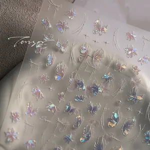 Macro shot of holographic butterfly nail art stickers with embossed floral line patterns
