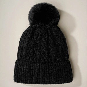 Unisex black cable knit winter beanie featuring a faux fur pompom and ribbed cuff detail
