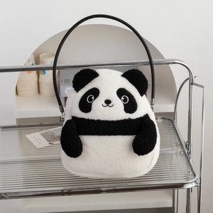 Detail of cute panda plush handbag with fluffy texture and round handle on a glass shelf