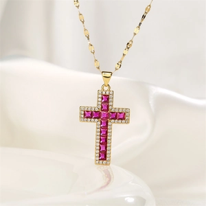 Detail of gold cross pendant with red gemstones and zircon on white silk