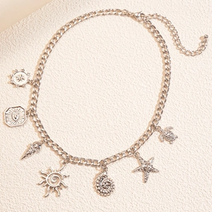 Macro detail of silver nautical necklace with starfish, turtle, and sun charms