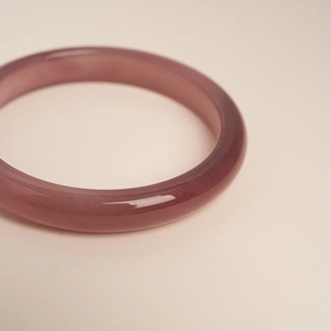 Macro shot of the translucent purple cat's eye stone bangle with a smooth polished finish