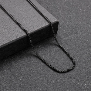 Macro shot of black titanium steel wheat chain necklace on a textured gift box