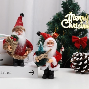 Dettaglio di Babbo Natale in peluche con abiti in velluto rosso, sacchi regalo e alberi