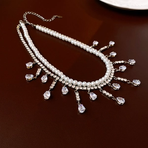 Vue détaillée du collier double rang avec perles blanches et pendentifs en zircon brillants