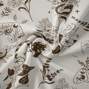 Close-up of white bohemian tapestry fabric with brown moth, snake and floral patterns