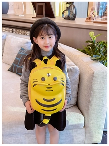 Detail view of the yellow cartoon tiger backpack on child model for casual school use