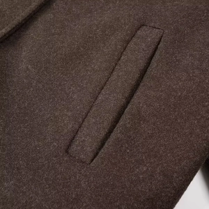 Détail de la couture de poche et texture laine épaisse sur manteau court pour femme