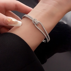 Close-up of a silver-toned double-layered knot bracelet with shimmering cubic zirconia
