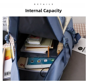 Detail view of large capacity blue canvas backpack showing interior storage for tablets