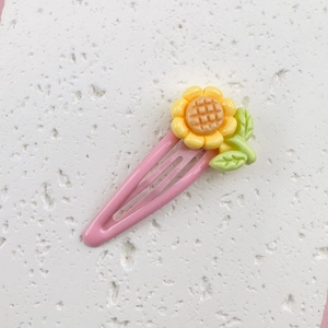 Close-up of pink sunflower BB hair clip with green leaves for little girls