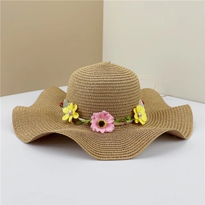 Women's wide brim straw sun hat with floral garland decor and wavy edges for beach