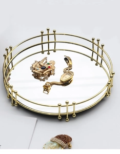Détail du plateau miroir doré avec cadre à double anneau et finitions perlées
