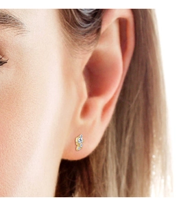 Close-up of golden S925 silver stud earrings with three sparkling moissanite stones