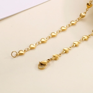 Macro shot of gold-plated stainless steel heart chain jewelry with a secure lobster clasp