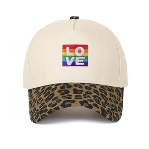 Dettaglio della toppa arcobaleno LOVE su cappello beige con visiera a stampa leopardata