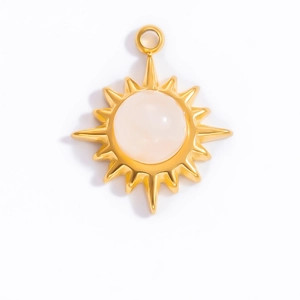 Detailed macro view of gold sunburst pendant with center round white gemstone inlay