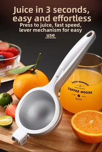 Macro shot of silver zinc alloy manual fruit juicer on a wooden board with citrus