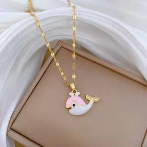 Luxurious gold titanium whale necklace with pink enamel and crystals on silk background