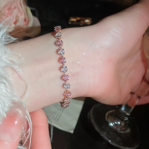 Detail of pink and white zircon flower pearl bracelet on model wrist in elegant setting