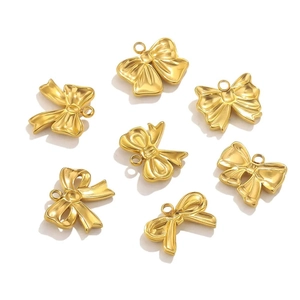 Close-up of golden bow-shaped metal pendants for DIY earring and necklace making