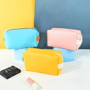 Three colorful PU leather makeup bags in blue, pink, and yellow with side handles