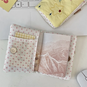 Close-up of fabric passport holder with pink polka dots and star embroidery details