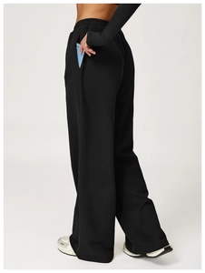 Detail showing the deep side pocket of black high-waisted wide-leg joggers with a phone