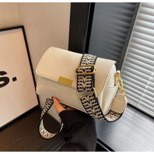 Détail du petit sac blanc crème avec texture litchi et large bandoulière géométrique