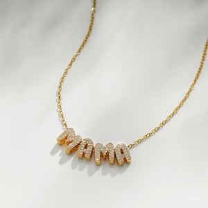 Macro detail of 18k gold plated MAMA letter pendant with sparkling zircon gemstones