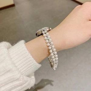 Detail of luxury silver watch with pearl bracelet strap and sparkling diamonds on wrist