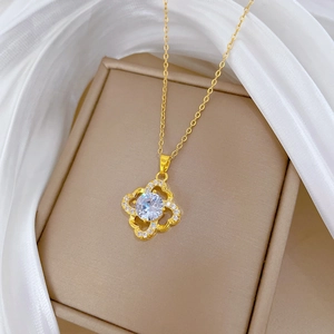 Detailed close-up of a hollow four-leaf clover pendant with sparkling crystals and gold chain