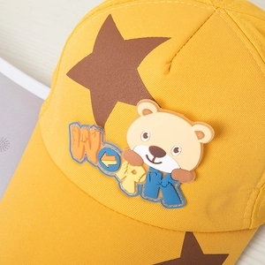 Détail d'une casquette jaune pour enfant avec ours en 3D et patch lettrage WORK