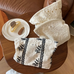 Close-up of beige lace embroidery cosmetic bags with Simple Wish fabric label