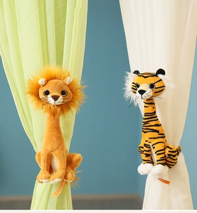 Detailed view of plush lion and tiger curtain tiebacks on fabric window treatments