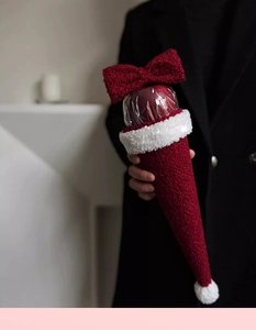 Close-up of red lamb velvet Christmas bouquet wrapping with a red bow tie detail
