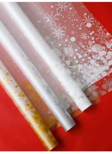 Papier cadeau de Noël translucide avec flocons blancs et dorés sur fond rouge vif