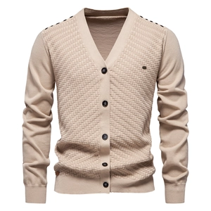 Macro detail of beige V-neck cardigan featuring geometric textured knit and brown buttons