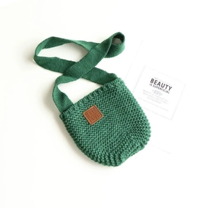 Borsa a tracolla in maglia verde con trama intrecciata e toppa decorativa in pelle