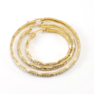 Three-piece gold rhinestone hoop earrings set with textured wave design on white background