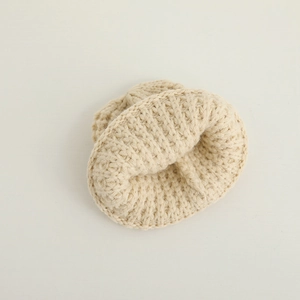 Knitted winter hat for babies in beige soft yarn with thick ribbed crochet texture