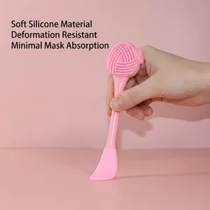 Pink dual-head silicone facial brush with textured cleanser and mask applicator