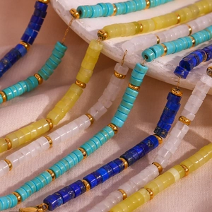 Macro detail of colorful natural stone beaded necklace set with golden metal spacers