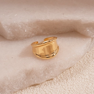 Detailed view of an irregular gold-plated open ring on a decorative white stone