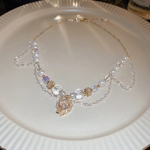 Détail du collier à pendentif cœur vintage avec perles et cristaux sur plat céramique