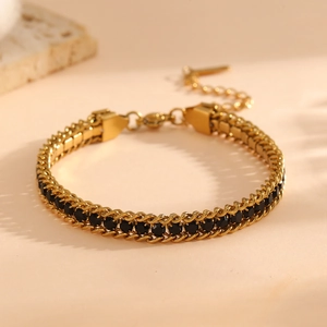 Detail of gold woven chain bracelet with black multifaceted zircons and adjustable clasp
