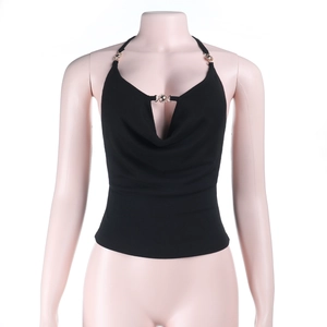 Detail of black cowl neck halter top with a decorative golden sun charm on a mannequin
