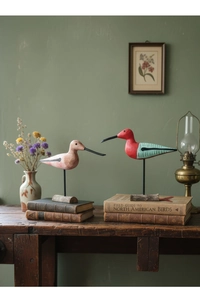 Detail of handcrafted Nordic style hand-painted wooden birds on a rustic desk