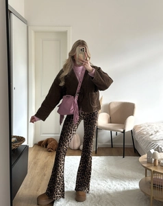 Gedetailleerd zicht op flared broek met luipaardprint en bruin gewatteerd jack