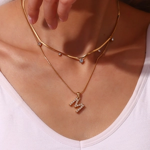 Detail of 18K gold-plated snake chain and pearl initial M pendant on model